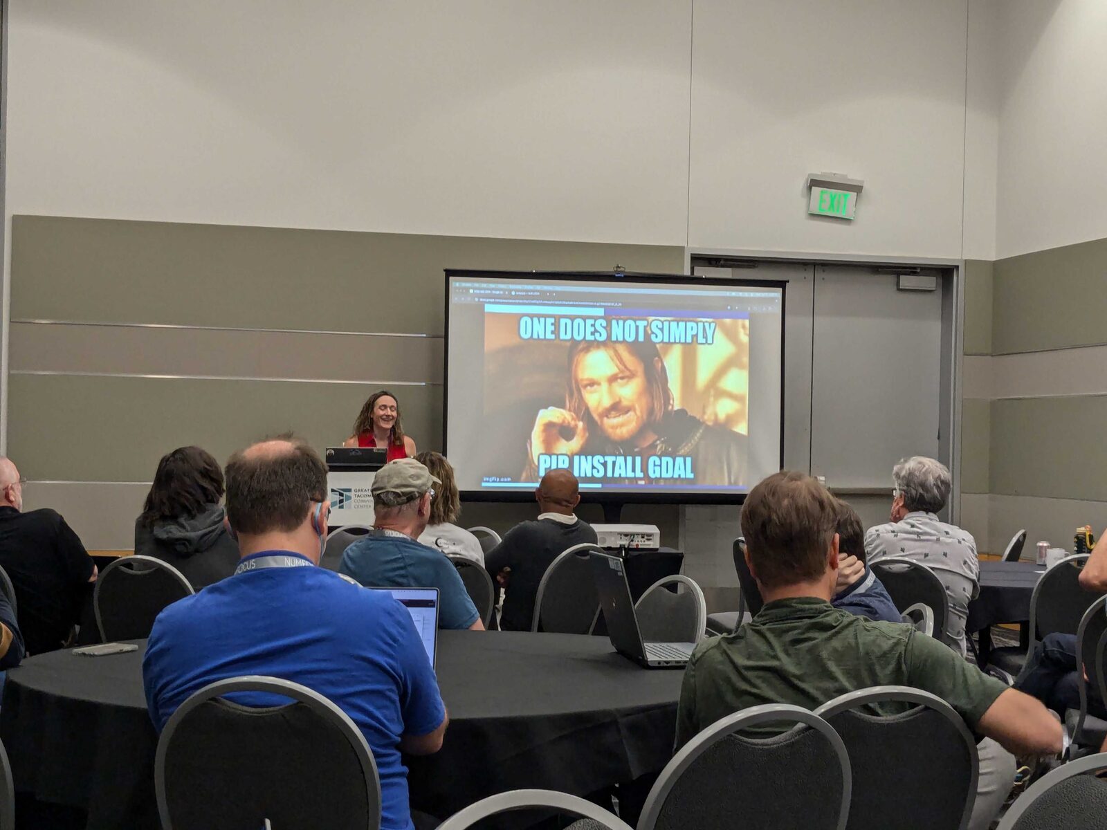 Image of me with my eyes closed chuckling as people laugh at the meme on the screen. The meme has Boromir, played by Sean Bean in the Lord of the Rings Trilogy, making a circle with his right hand with the words 'One does not simply pip install GDAL overlaid on the image.'' style='width: 90%;